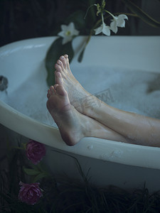 浴缸里的年轻女子双脚放在浴缸边缘专注于脚