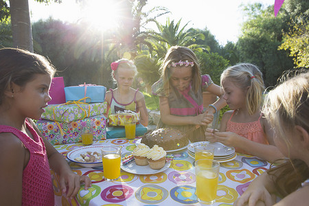 女孩和朋友一起切生日蛋糕