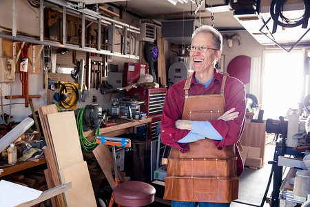 快乐的老人在他的木工车间里的肖像
