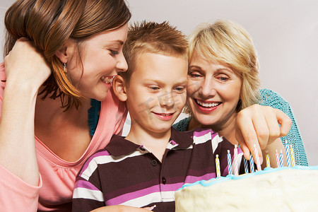 定位孩子摄影照片_奶奶男孩和妈妈在装饰蛋糕