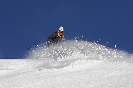 女子单板滑雪运动员在雪地里转弯
