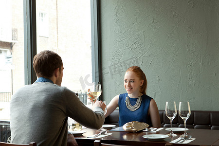 餐馆里的年轻夫妇在为酒杯干杯