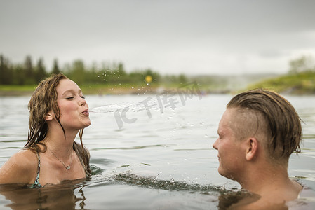 门德尔松摄影照片_冰岛福夫迪尔年轻夫妇在秘密泻湖温泉喷水