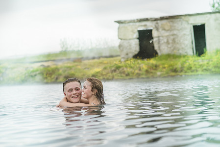 冰岛福夫迪尔年轻夫妇在秘密泻湖温泉拥抱