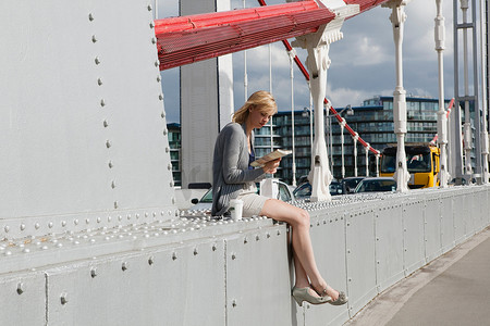 动物的书籍摄影照片_坐在桥上看书的女人