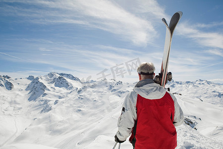 成年男子手持滑雪的背影