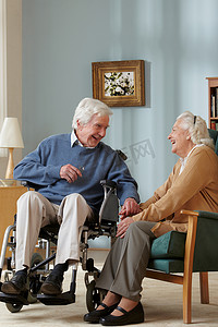 轮椅下坡摄影照片_养老院的老年夫妇轮椅上的男人