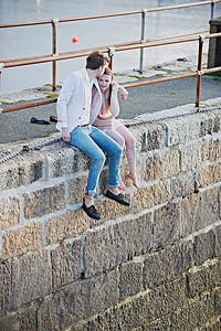 亲嘴视频摄影照片_一对夫妇坐在港口的栏杆上
