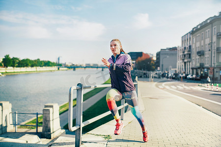 追逐摄影照片_沿着河边跑步的中年女运动员