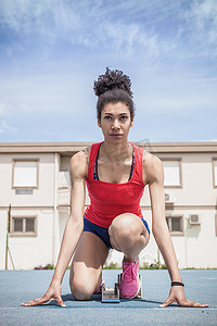 香港赛马摄影照片_年轻的女短跑运动员在跑道上取得了成绩