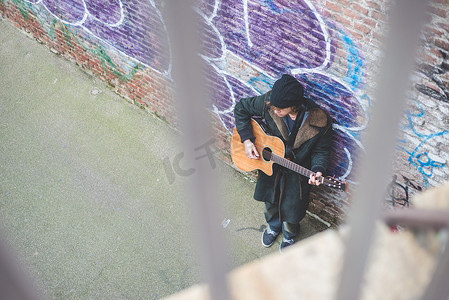 在运河墙旁弹吉他的音乐家意大利米兰