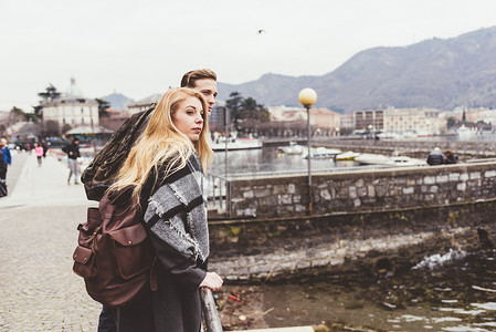 两个人抬头看摄影照片_年轻夫妇抬头看着意大利科莫湖畔