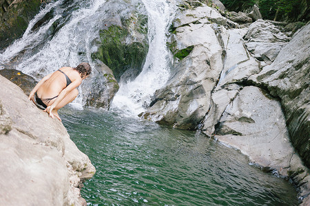 思考加一摄影照片_一名女子打算带着瀑布跳进树林中的一个游泳洞
