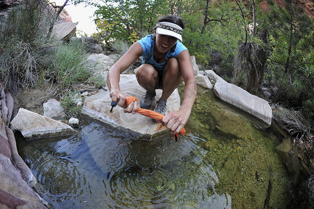 美国内华达州威尔逊山女徒步旅行者在岩池里漂洗衣服