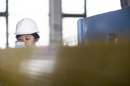 女性职业照摄影照片_技术人员在工厂检查仪表上的读数