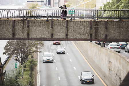 拍照旅游景点摄影照片_一名年轻女子站在人行天桥上拍照