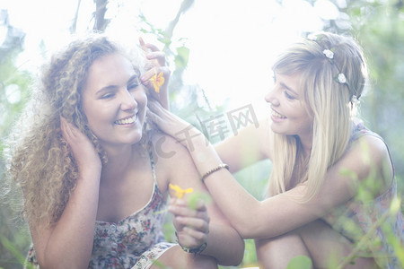 两个十几岁的女孩在林地里开着野花