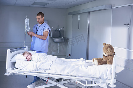 医院儿科病房男童调整静脉滴注的男护士
