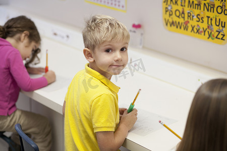 十里红妆摄影照片_蹒跚学步的孩子在教室里写字