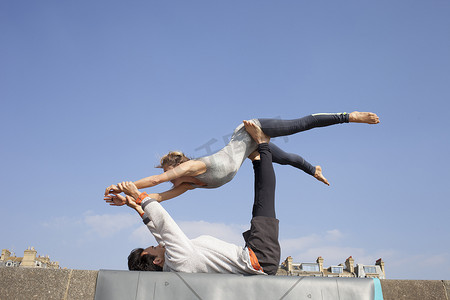 在墙上练习杂技瑜伽的男人和女人