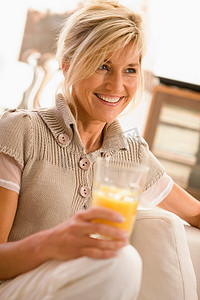 一杯橙汁摄影照片_喝一杯橙汁的女人