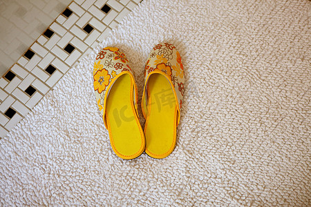 上卫生间摄影照片_地毯上的一双黄色拖鞋