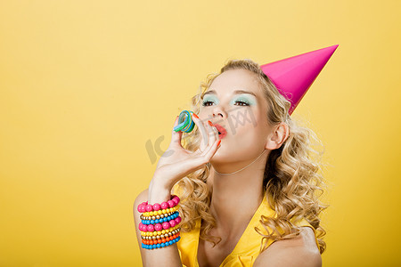 聚会摄影照片_戴着派对帽和派对飘带的年轻女子