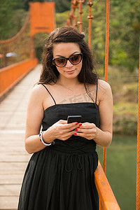 一名女子在桥上使用智能手机