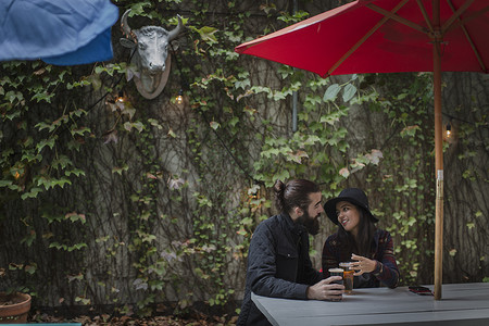 美国纽约布鲁克林年轻夫妇傍晚在啤酒花园聊天