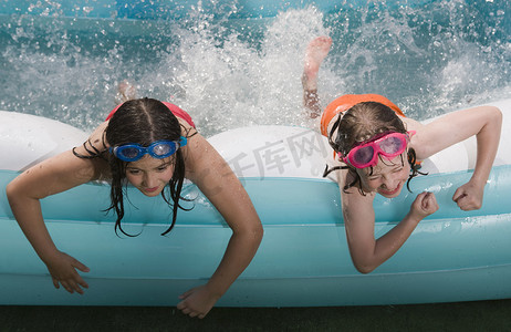 两个女孩躺在前面的水池里泼水