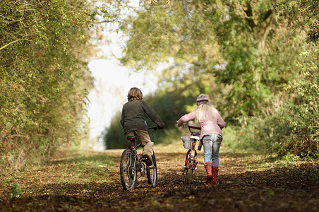 男孩和女孩在农村骑自行车