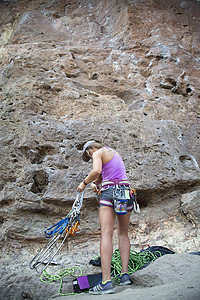 带着攀岩装备的妇女在岩壁上的背影