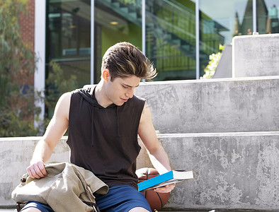 青年大学习摄影照片_一个年轻人坐在台阶上在户外看书
