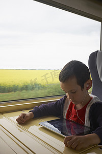 火车上的男孩在读数字平板电脑