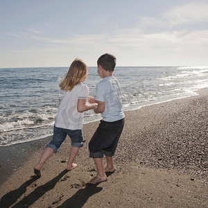 男孩和女孩在海滩上跑步