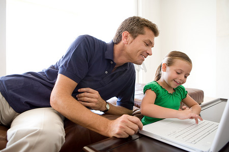父亲和女儿使用笔记本电脑