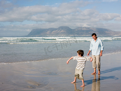 十里桃花字体摄影照片_父亲和儿子向海里扔石头