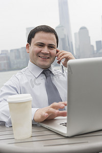 美国新泽西州泽西市一名商人在户外使用笔记本电脑