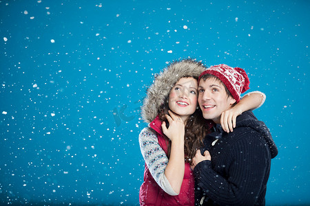 一对微笑的情侣在雪中拥抱