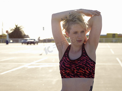 灵活性训练摄影照片_一名年轻女子在停车场进行热身训练