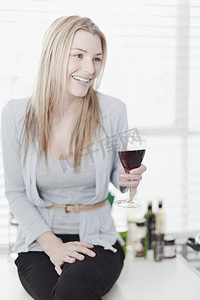 微笑的女人喝着一杯酒