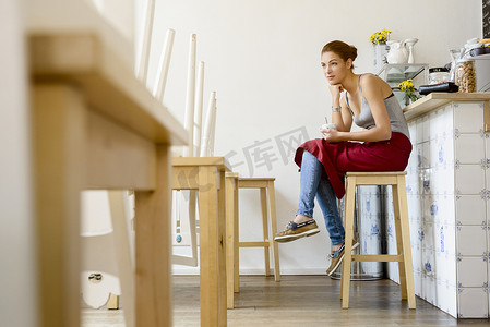 坐在凳子上的人摄影照片_咖啡馆的女服务员坐在凳子上