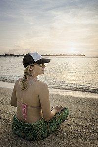 印度尼西亚龙目岛吉利梅诺一名年轻女子盘腿坐在海滩上