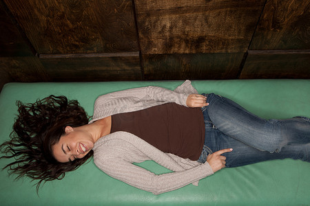 年轻女子躺在绿色床垫上