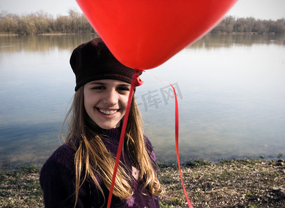 河边的少女摄影照片_河边的女孩手持红色气球