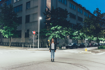 夜里站在城市路口的年轻女子肖像