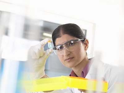 女科学家在实验室举起并检查化学样品