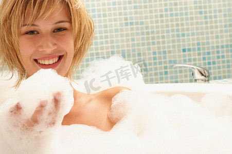 泡泡浴中面带微笑的年轻女子