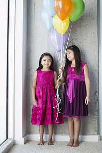两个拿着气球的年轻女孩的肖像