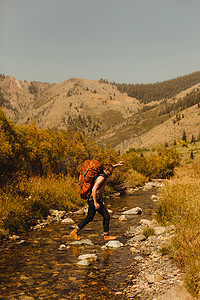 男人背着背包穿过小溪矿物之王美国加利福尼亚州红杉国家公园